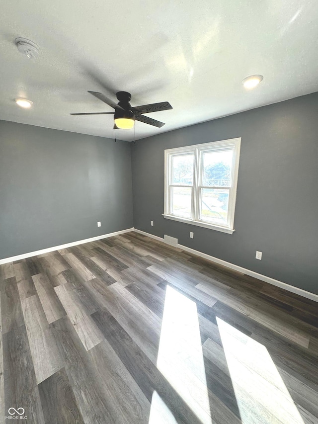 spare room featuring ceiling fan, dark hardwood / wood-style flooring, and a textured ceiling