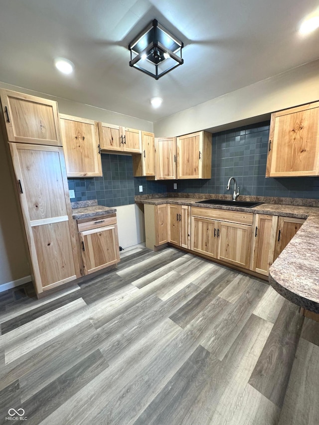 kitchen with decorative backsplash, light brown cabinets, light hardwood / wood-style flooring, and sink