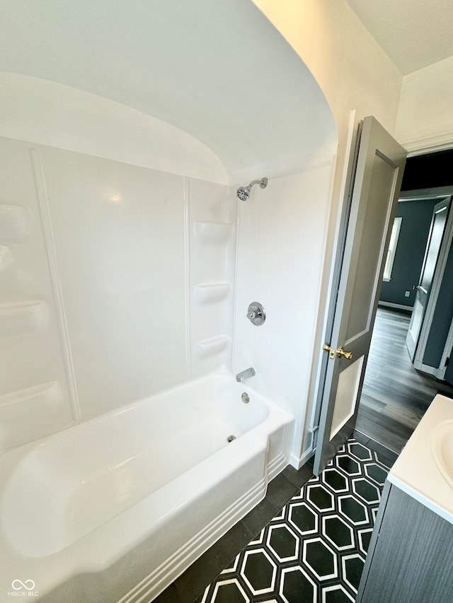 bathroom featuring hardwood / wood-style flooring, vanity, and shower / washtub combination