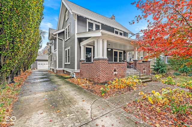 view of front of house featuring an outbuilding, a garage, and covered porch