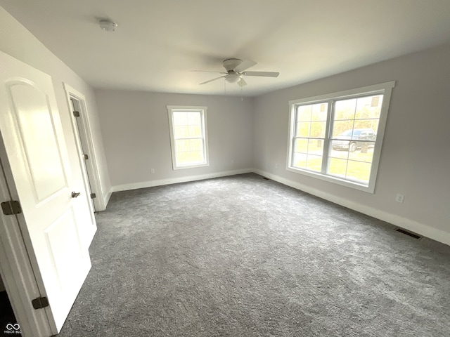 carpeted spare room with a wealth of natural light and ceiling fan