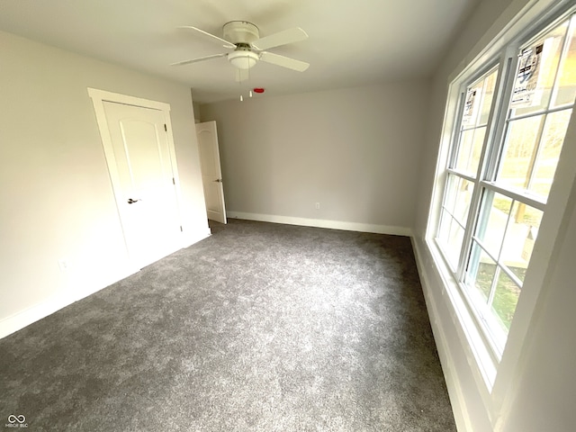 unfurnished bedroom featuring ceiling fan and dark colored carpet