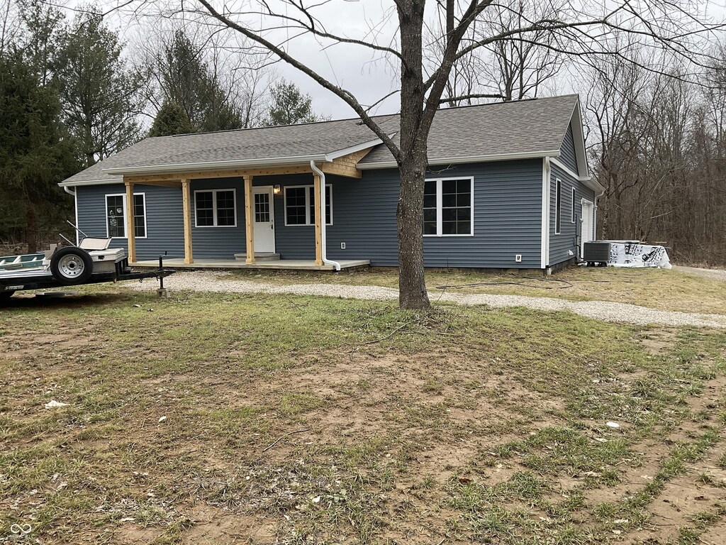 ranch-style house with central AC, covered porch, and a front lawn