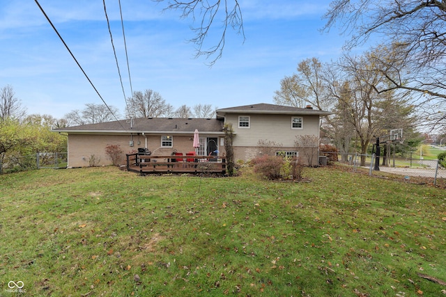 rear view of property featuring a lawn and a wooden deck