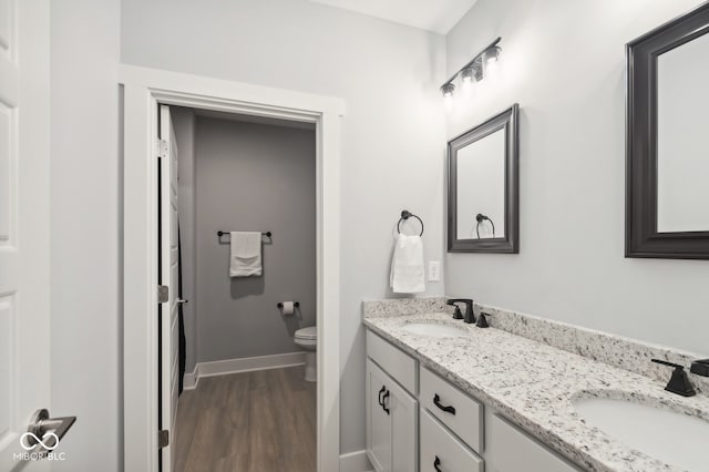 bathroom featuring wood-type flooring, toilet, and vanity