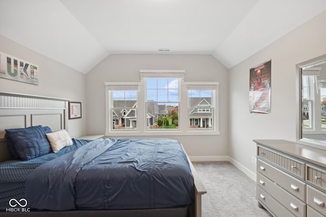 bedroom with light colored carpet and vaulted ceiling