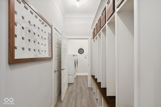 interior space with independent washer and dryer, light hardwood / wood-style flooring, and ornamental molding