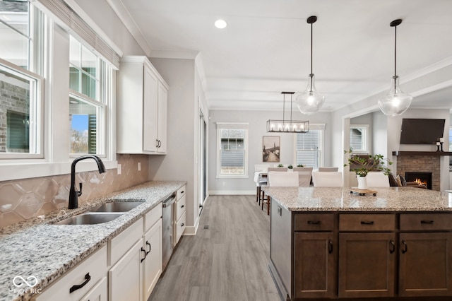 kitchen with white cabinetry, sink, a healthy amount of sunlight, and light hardwood / wood-style flooring