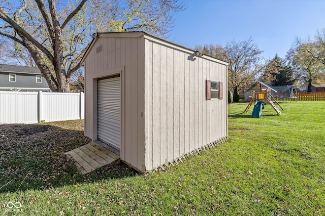 view of outdoor structure with a playground, a yard, and a trampoline