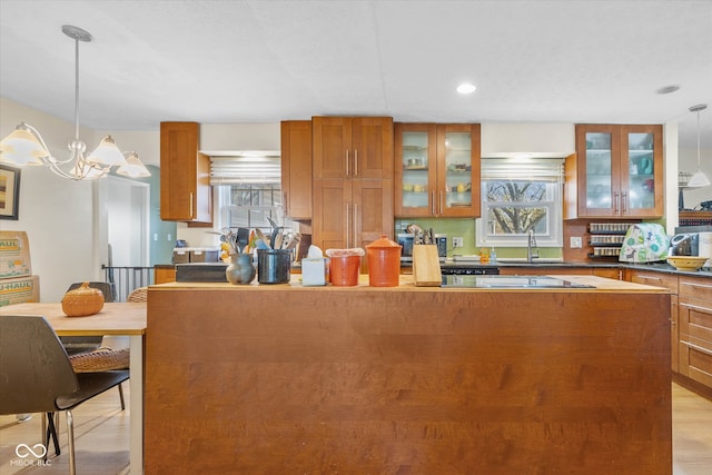 kitchen featuring pendant lighting, a wealth of natural light, sink, and light wood-type flooring