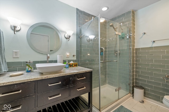 bathroom featuring vanity, toilet, and a shower with shower door