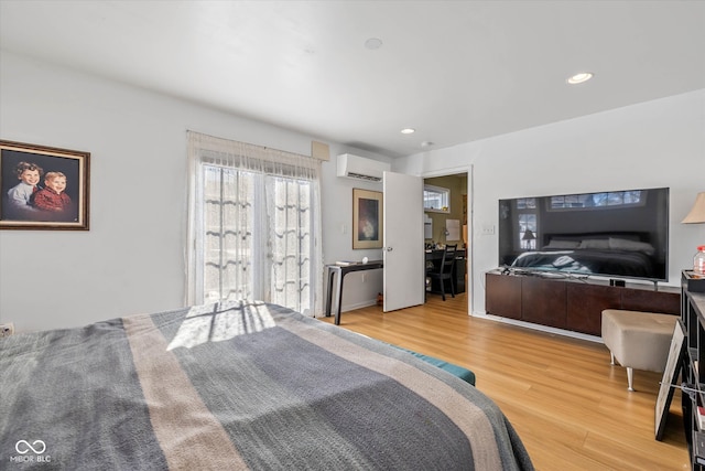 bedroom featuring hardwood / wood-style floors and an AC wall unit