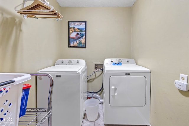 clothes washing area featuring washing machine and dryer and light tile patterned floors