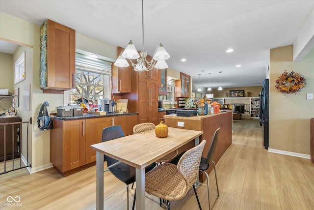 dining area with a chandelier, sink, and light hardwood / wood-style floors