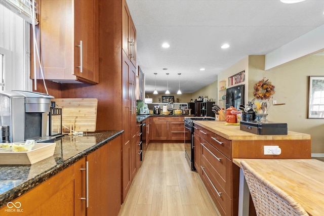 595 Hawthorne Dr, Carmel, IN 46033 - kitchen featuring butcher block counters, black electric range oven, light wood-style flooring, brown cabinets, and pendant lighting