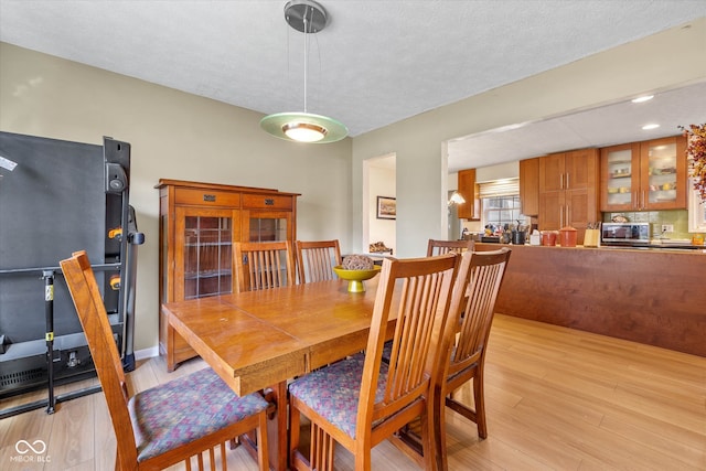 dining space featuring a textured ceiling and light hardwood / wood-style floors