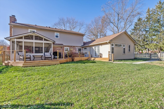 back of house with a wooden deck, a lawn, and a sunroom