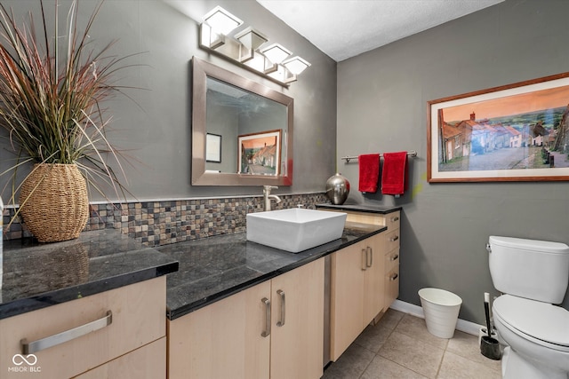 bathroom featuring toilet, backsplash, vanity, and tile patterned flooring