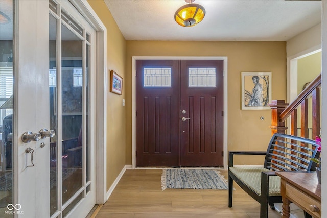 595 Hawthorne Dr, Carmel, IN 46033 - entryway with wood finished floors, stairs, and baseboards