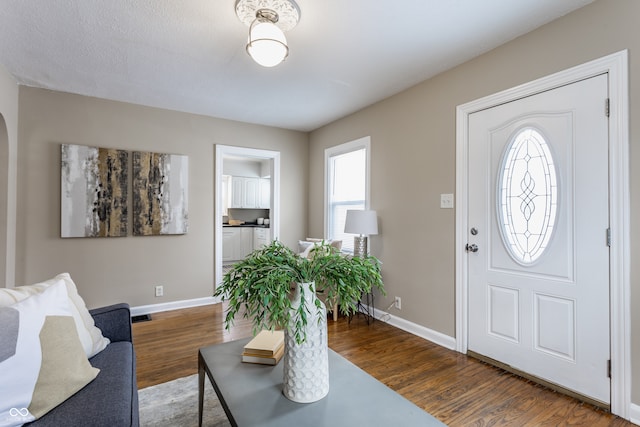 foyer with a textured ceiling and dark hardwood / wood-style floors