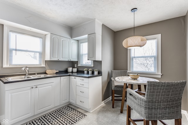 kitchen with white cabinets, sink, and a wealth of natural light