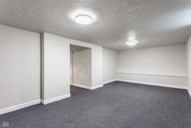 basement with dark carpet and a textured ceiling