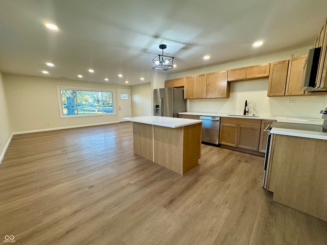 kitchen featuring light hardwood / wood-style flooring, sink, a kitchen island, appliances with stainless steel finishes, and decorative light fixtures