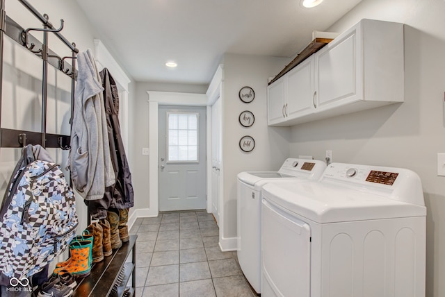 clothes washing area featuring washing machine and dryer, cabinets, and light tile patterned floors