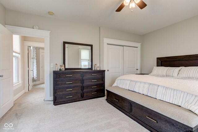 carpeted bedroom featuring ceiling fan and a closet