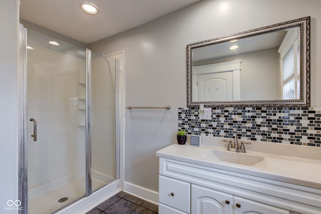 bathroom featuring walk in shower, backsplash, vanity, and tile patterned flooring