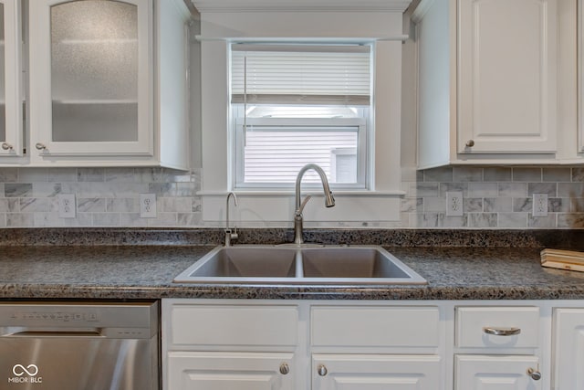 kitchen featuring decorative backsplash, white cabinetry, stainless steel dishwasher, and sink