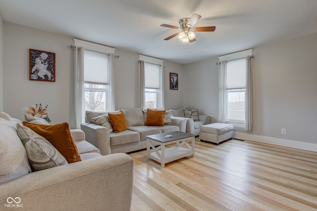 living room featuring light hardwood / wood-style flooring and ceiling fan