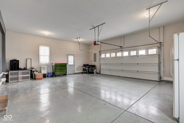 garage featuring a garage door opener, electric panel, and white refrigerator