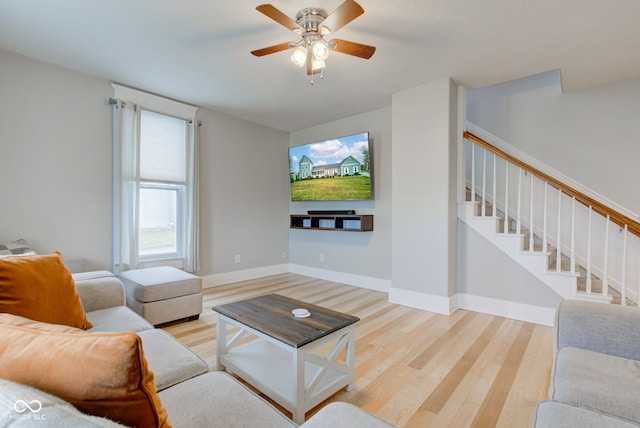 living room featuring hardwood / wood-style floors and ceiling fan