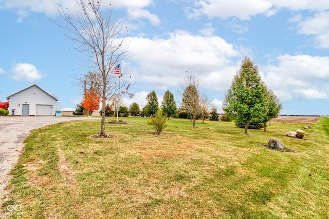 view of yard featuring a garage and a rural view