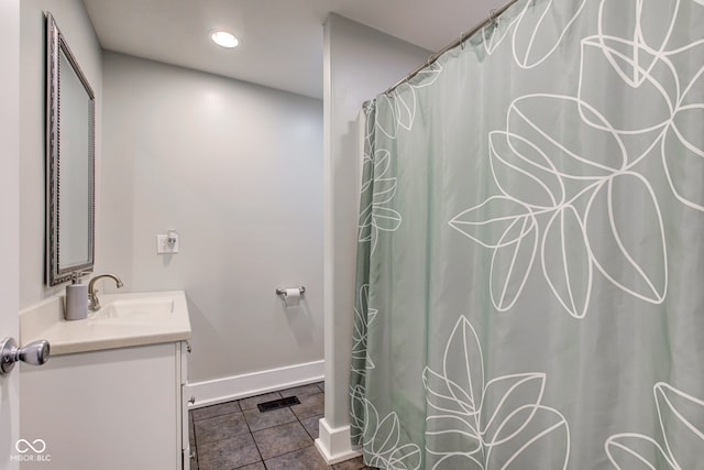 bathroom with walk in shower, vanity, and tile patterned floors