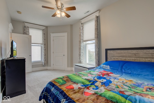 bedroom featuring light colored carpet and ceiling fan