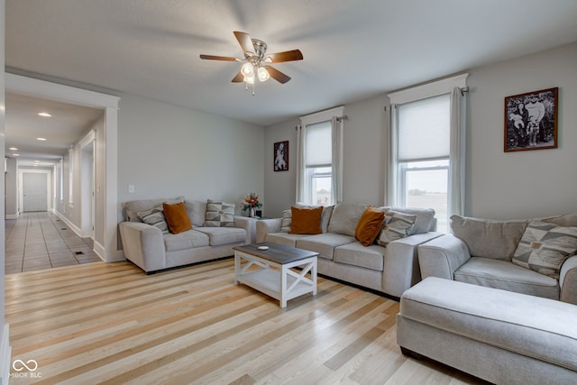 living room with light hardwood / wood-style flooring and ceiling fan