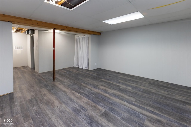 basement with dark hardwood / wood-style floors and a drop ceiling