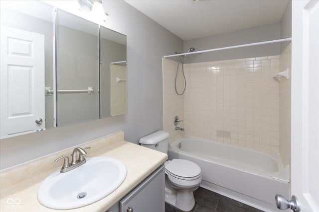 full bathroom featuring tile patterned flooring, vanity, toilet, and tiled shower / bath