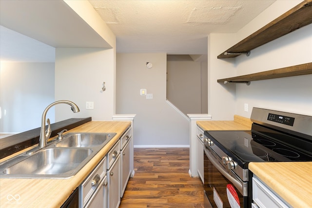 kitchen featuring dark hardwood / wood-style flooring, stainless steel electric range oven, sink, and a textured ceiling