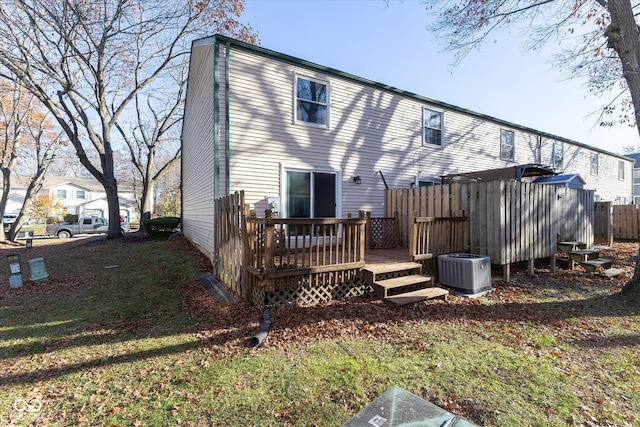 rear view of house with a yard, a wooden deck, and central air condition unit