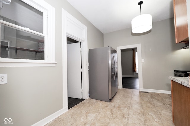 kitchen with stainless steel refrigerator with ice dispenser and decorative light fixtures