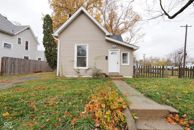 bungalow-style home with a front yard