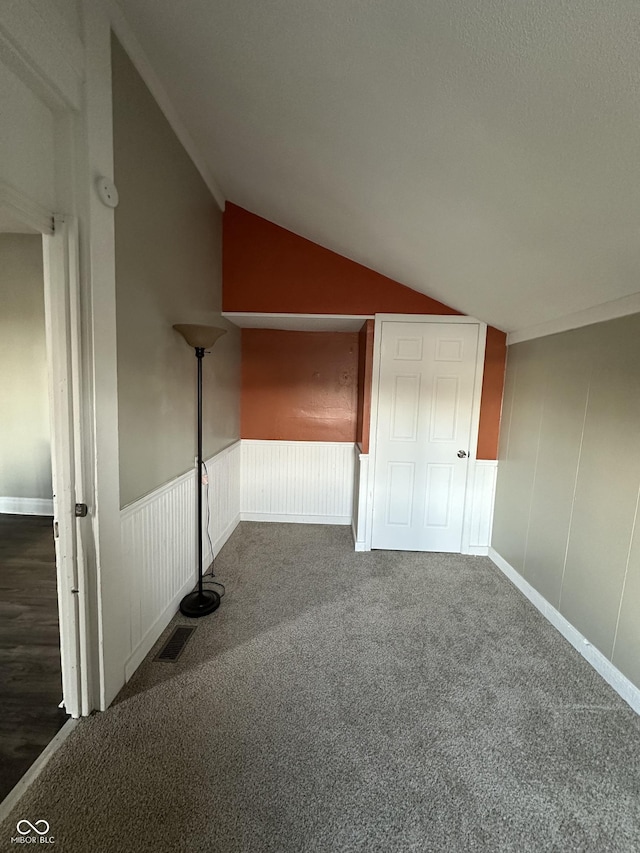 additional living space with lofted ceiling and dark carpet