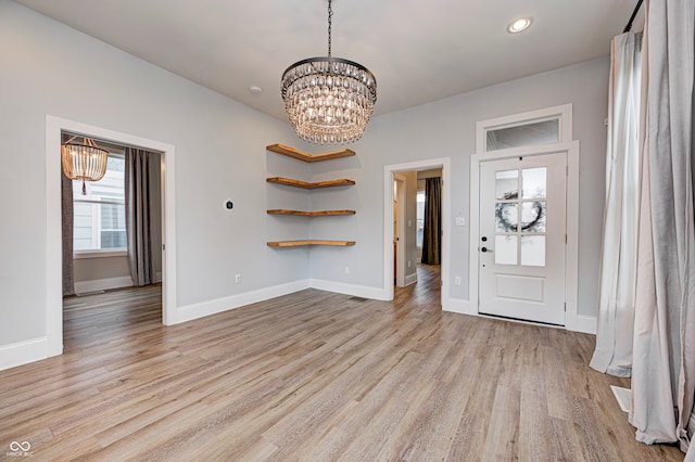 foyer entrance featuring an inviting chandelier and light wood-type flooring