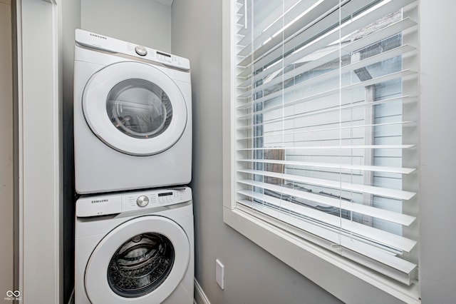 clothes washing area featuring stacked washer and clothes dryer