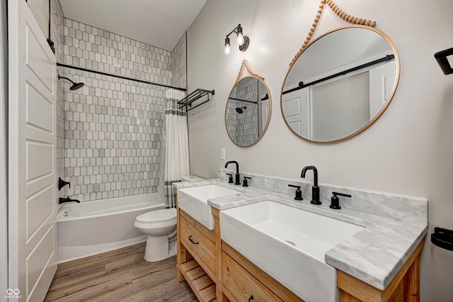 full bathroom with vanity, hardwood / wood-style floors, tiled shower / bath combo, and toilet