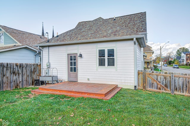 rear view of house featuring a deck and a lawn