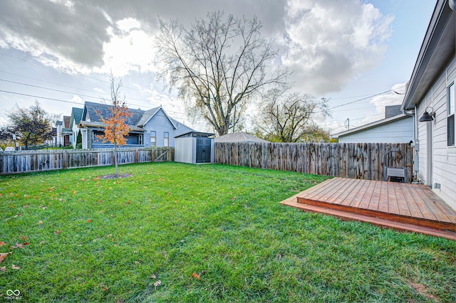 view of yard with a wooden deck and a storage unit